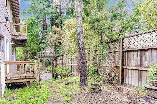 view of yard with a deck, a fenced backyard, and a pergola