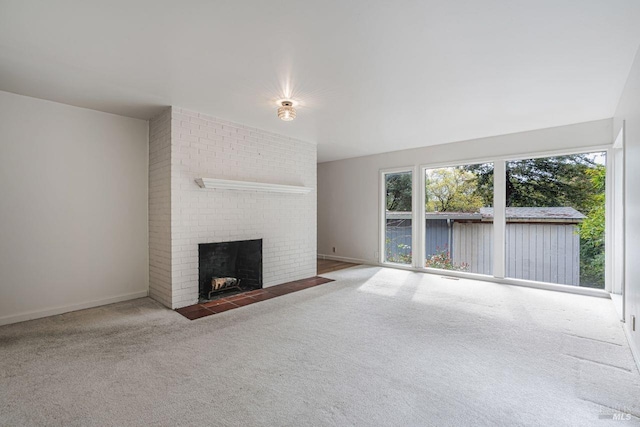 unfurnished living room with carpet flooring, a fireplace, and baseboards