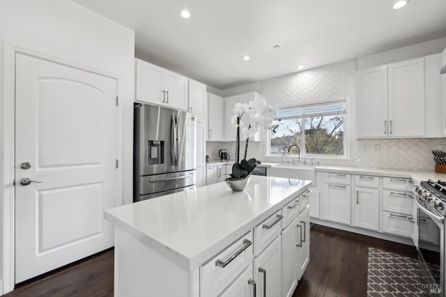 kitchen featuring a sink, white cabinets, backsplash, and stainless steel appliances