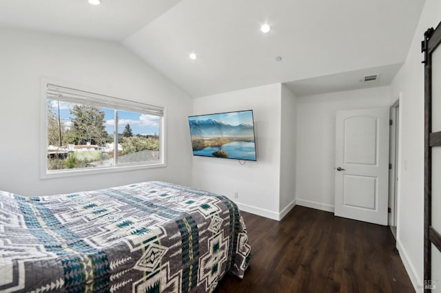 bedroom featuring dark wood-style floors, visible vents, baseboards, vaulted ceiling, and a barn door