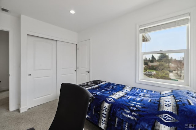 carpeted bedroom with a closet, visible vents, and recessed lighting