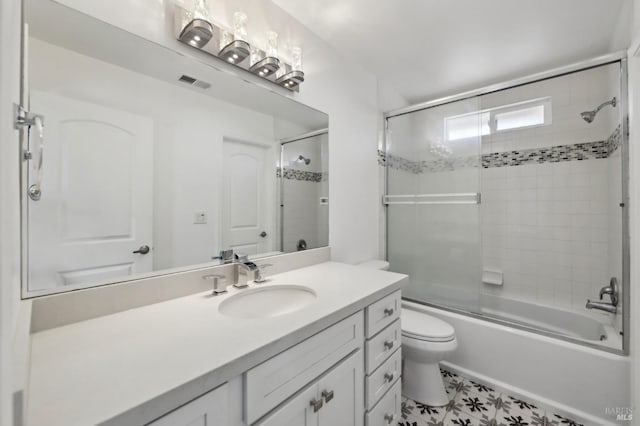 full bathroom featuring vanity, toilet, visible vents, and enclosed tub / shower combo