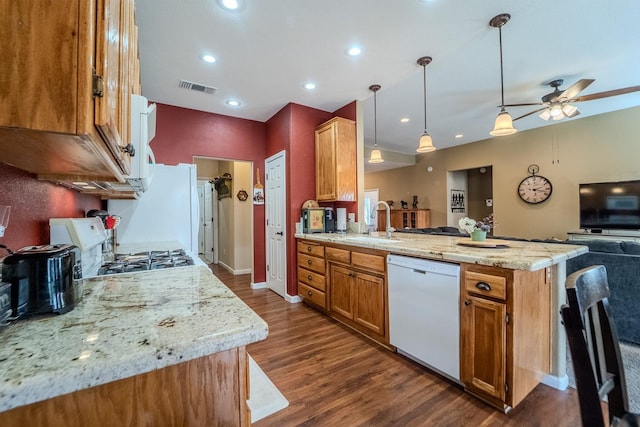 kitchen with visible vents, dark wood-type flooring, a peninsula, white appliances, and a sink