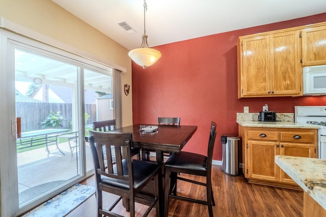 dining room featuring visible vents, baseboards, and dark wood-style floors