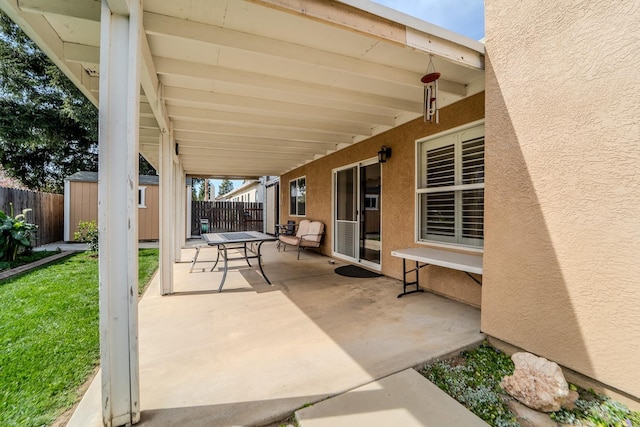 view of patio with an outbuilding, a storage unit, and a fenced backyard