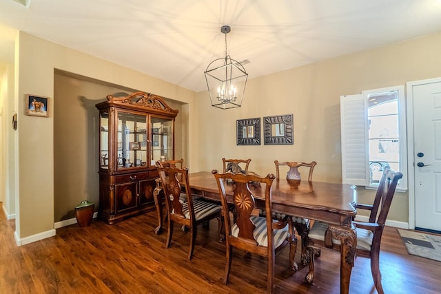 dining area with an inviting chandelier, dark wood-type flooring, and baseboards