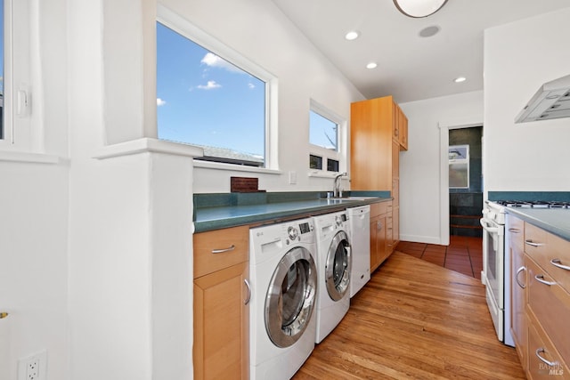 washroom with a sink, baseboards, recessed lighting, light wood-style floors, and separate washer and dryer