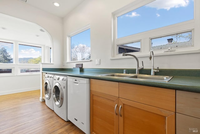 laundry room featuring light wood-type flooring, a sink, recessed lighting, separate washer and dryer, and baseboards