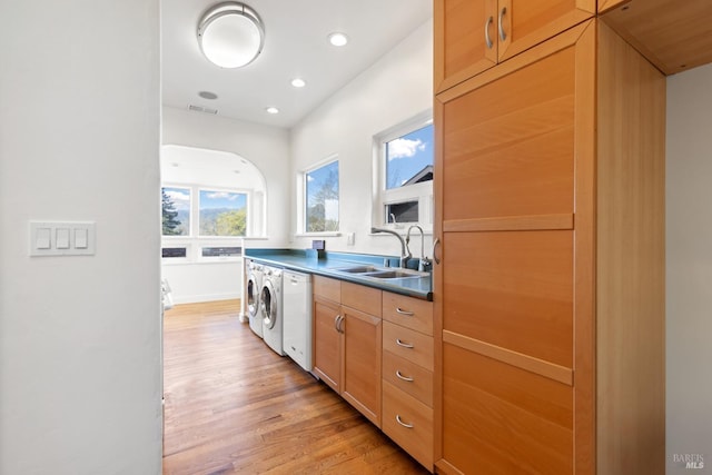 kitchen featuring visible vents, recessed lighting, a sink, dark countertops, and light wood-type flooring