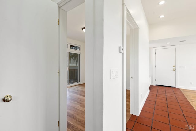 hallway featuring wood finished floors, recessed lighting, and baseboards