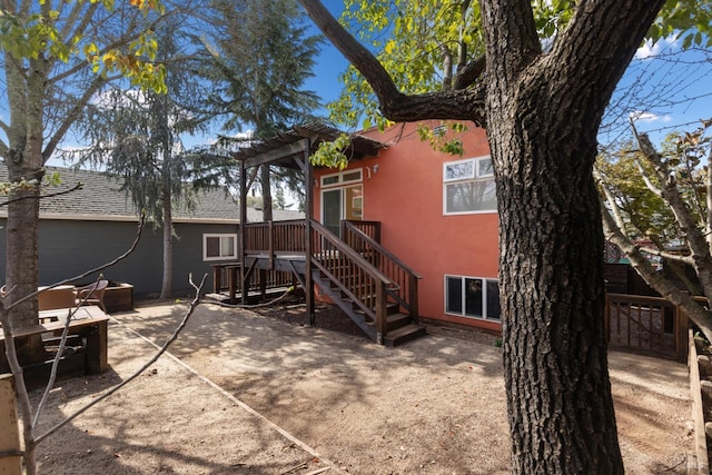 back of house featuring stairway, a patio, a deck, and stucco siding