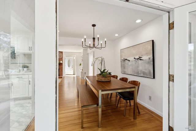 dining room with a notable chandelier, light wood-style floors, recessed lighting, and baseboards