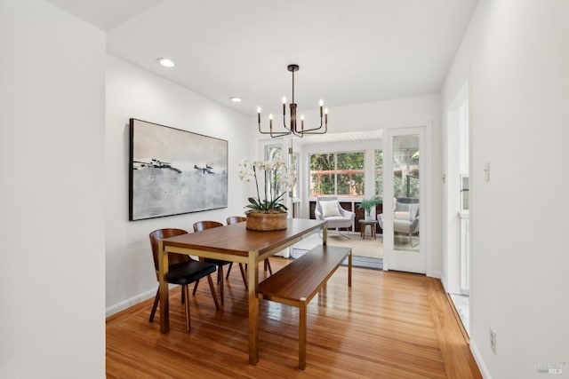 dining room featuring baseboards, recessed lighting, an inviting chandelier, and light wood-style floors