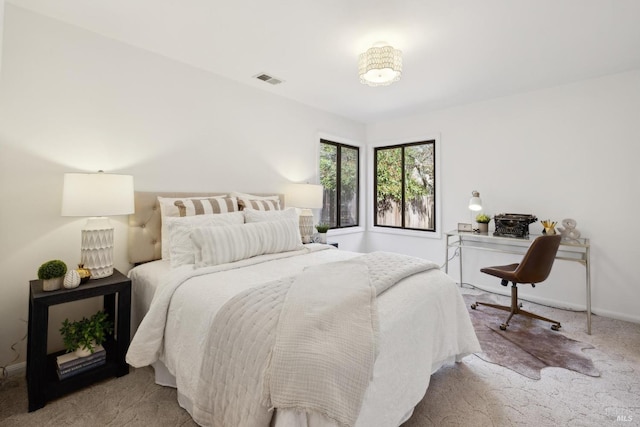 carpeted bedroom with visible vents and baseboards