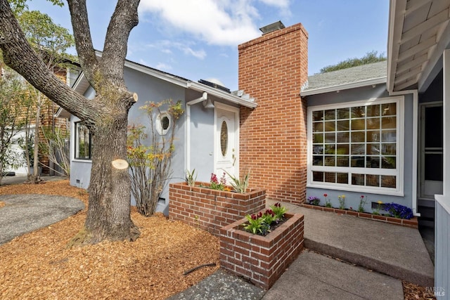 exterior space with stucco siding and a chimney