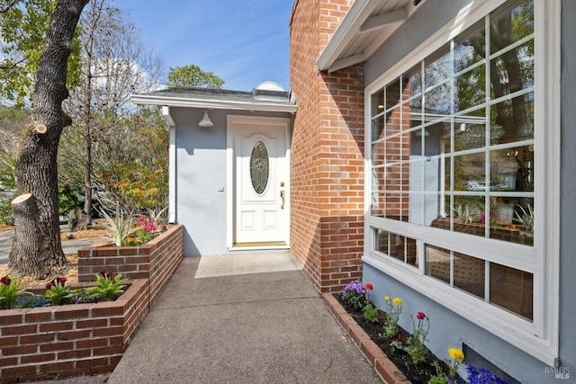 view of exterior entry with brick siding