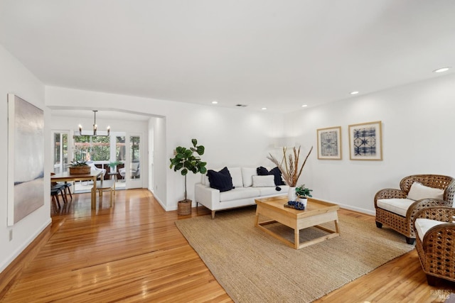 living area with visible vents, light wood-style flooring, recessed lighting, baseboards, and a chandelier