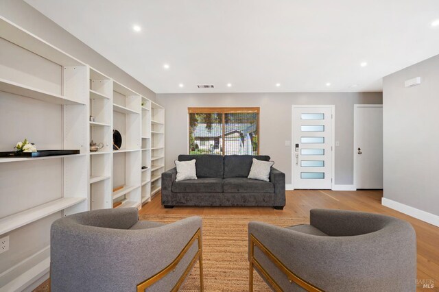 living room with visible vents, recessed lighting, baseboards, and wood finished floors