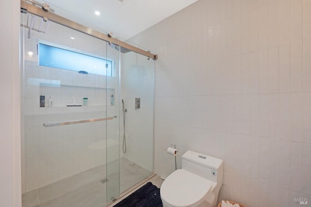 bathroom featuring toilet, a stall shower, and tile walls