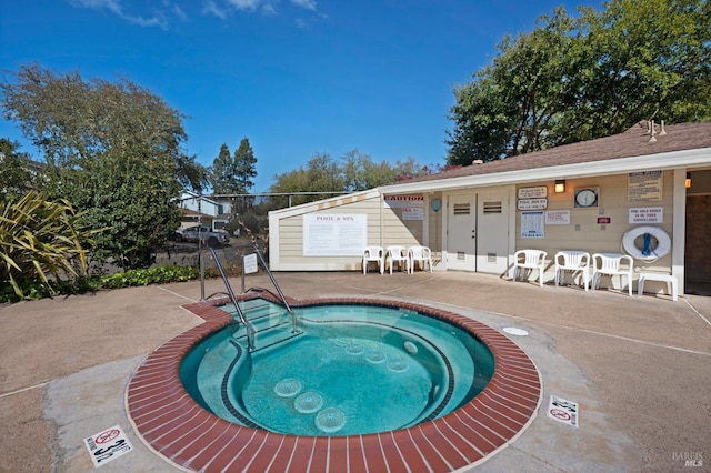 view of swimming pool with a patio area and a hot tub