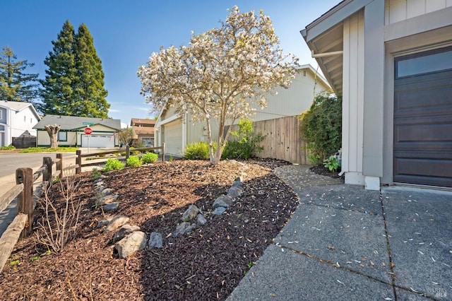 view of home's exterior with a residential view, a garage, and fence