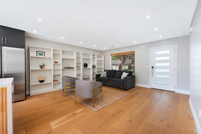 living room with recessed lighting, baseboards, and light wood-style flooring