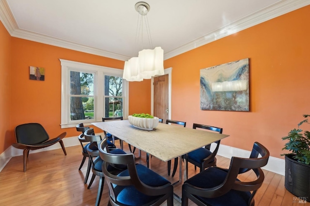 dining room featuring ornamental molding, baseboards, and light wood-style floors