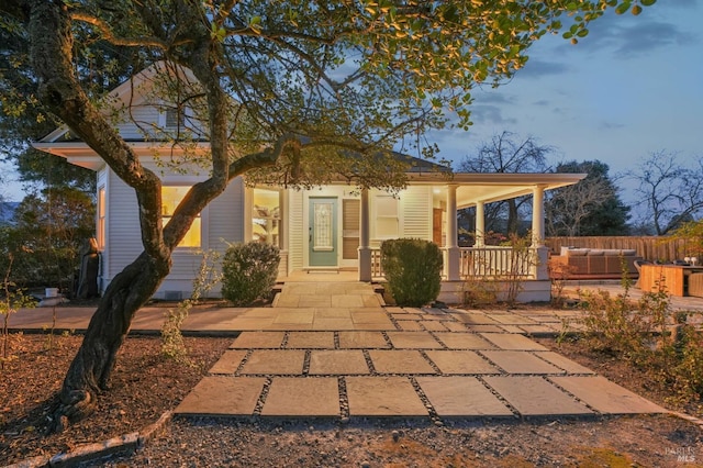 back of house with a porch and an outdoor living space