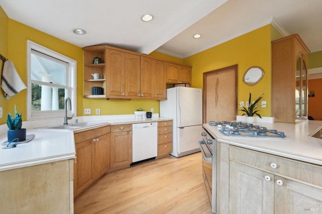 kitchen with ornamental molding, light wood-style flooring, a sink, and white appliances