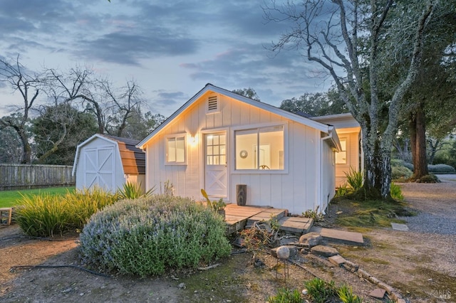 view of front of house featuring fence, an outbuilding, and board and batten siding