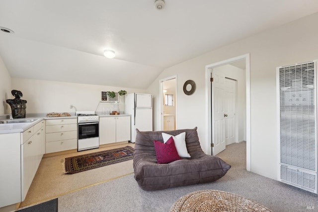 kitchen featuring a sink, a heating unit, white appliances, light countertops, and light carpet