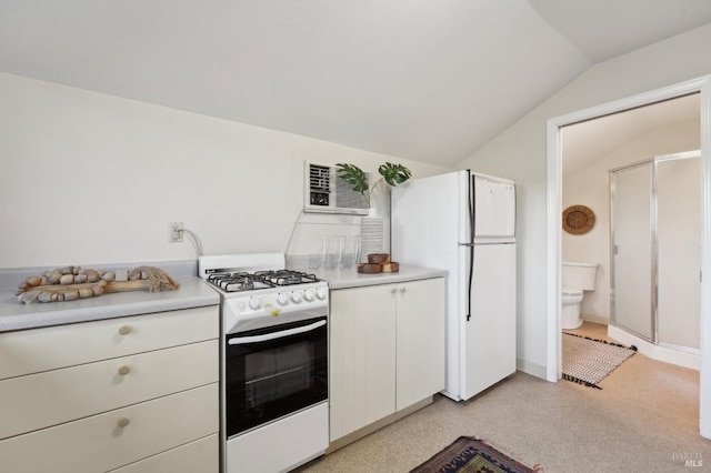 kitchen featuring lofted ceiling, white appliances, light countertops, and white cabinets