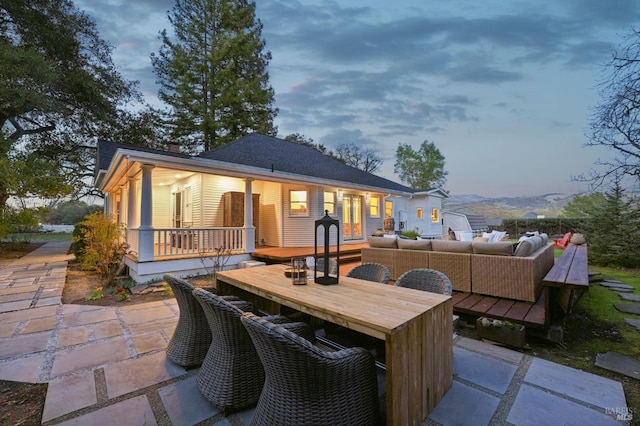 back of property with an outdoor living space, a patio area, and outdoor dining area