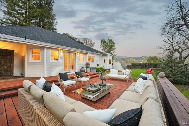 deck featuring an outdoor hangout area, a storage shed, fence, and french doors