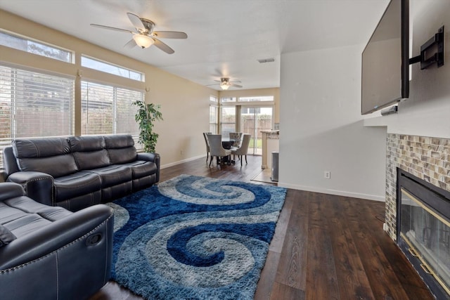 living room with visible vents, a brick fireplace, ceiling fan, baseboards, and wood finished floors