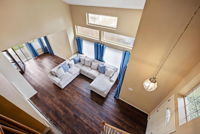 living room with high vaulted ceiling, baseboards, and dark wood-style flooring