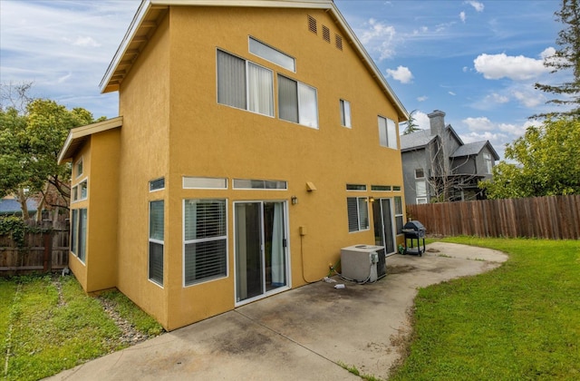 back of property with stucco siding, a patio, and fence