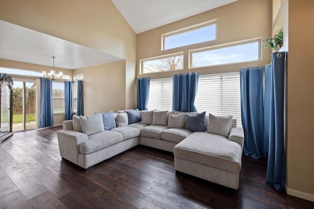 living room with dark wood finished floors, a notable chandelier, baseboards, and high vaulted ceiling