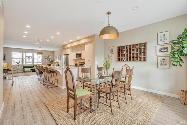 dining room with baseboards, recessed lighting, and light wood-type flooring