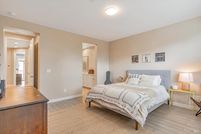bedroom featuring light wood-style flooring, ensuite bath, and baseboards