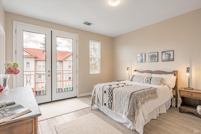 bedroom with visible vents, baseboards, access to exterior, wood tiled floor, and french doors