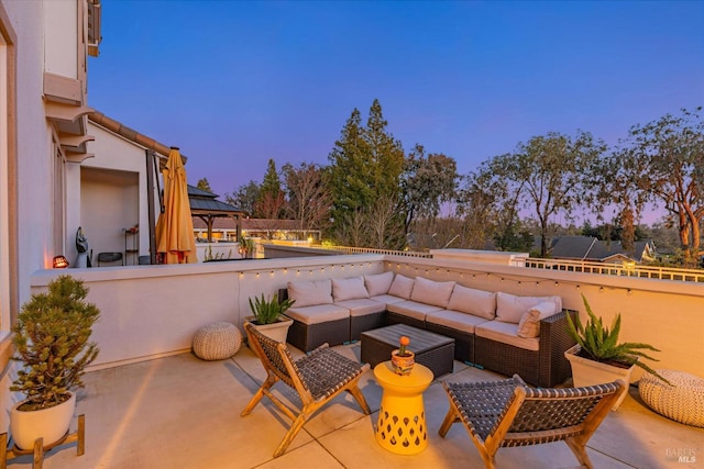 patio terrace at dusk with an outdoor living space and a gazebo