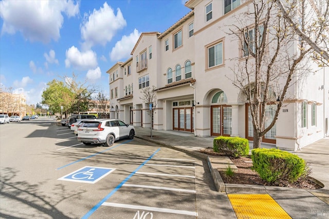 view of building exterior with uncovered parking and a residential view