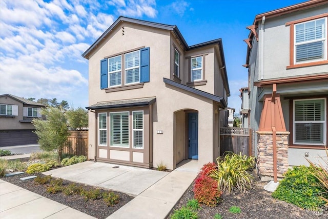 view of front of property with stucco siding and fence