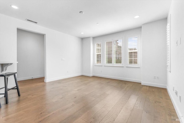 empty room with recessed lighting, visible vents, light wood-style flooring, and baseboards