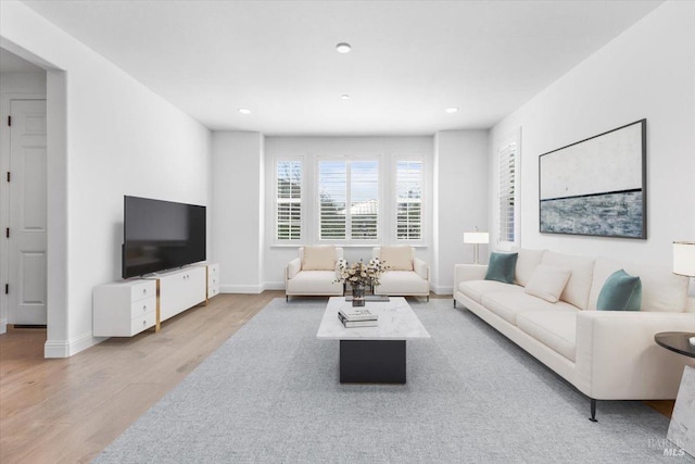 living room with recessed lighting, baseboards, and wood finished floors