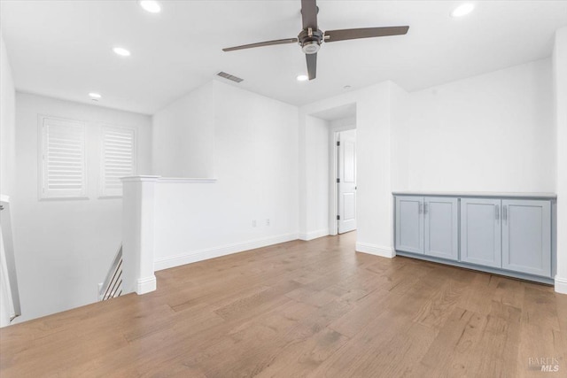 empty room with a ceiling fan, wood finished floors, visible vents, baseboards, and recessed lighting