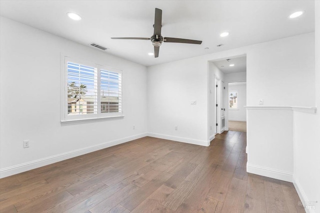unfurnished room featuring recessed lighting, wood finished floors, visible vents, and baseboards