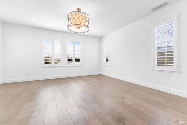 empty room with visible vents, baseboards, and wood finished floors