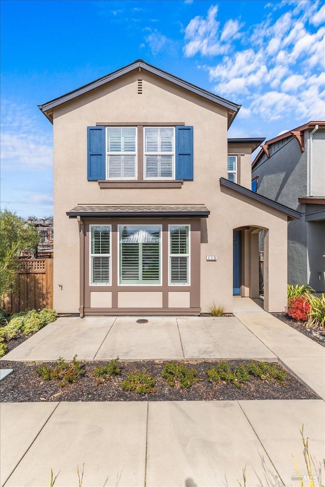 traditional-style house with fence and stucco siding